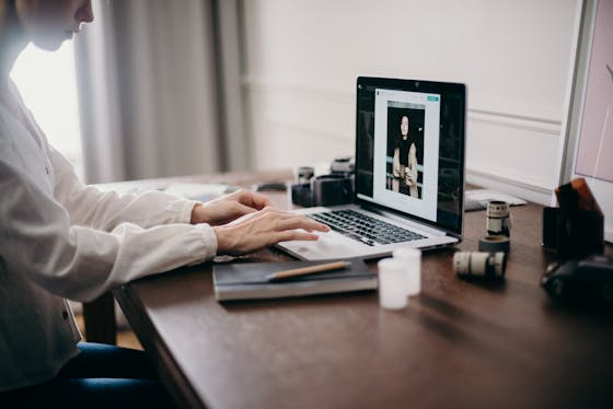 A freelancer working on a laptop in a cozy home office, focusing on creative design tasks. Professional Headshot Photographer in Austin