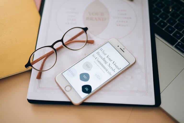 Close-up of glasses and smartphone on document about visual branding, perfect for business concepts. Professional branding photos