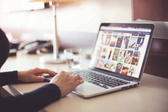 Close-up of hands typing on a laptop with an image gallery open on the screen. Social Media Branding Photos | Headshots Personal Branding Resources