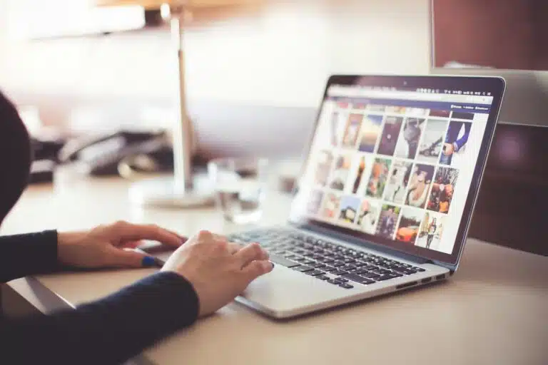 Close-up of hands typing on a laptop with an image gallery open on the screen. Social Media Branding Photos | Headshots Personal Branding Resources