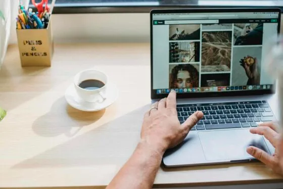 Brand Photos vs Stock Photos: Why Original Imagery Converts 58 Crop anonymous male searching photos on internet using netbook while drinking coffee at table | Brand Photos vs Stock Photos
