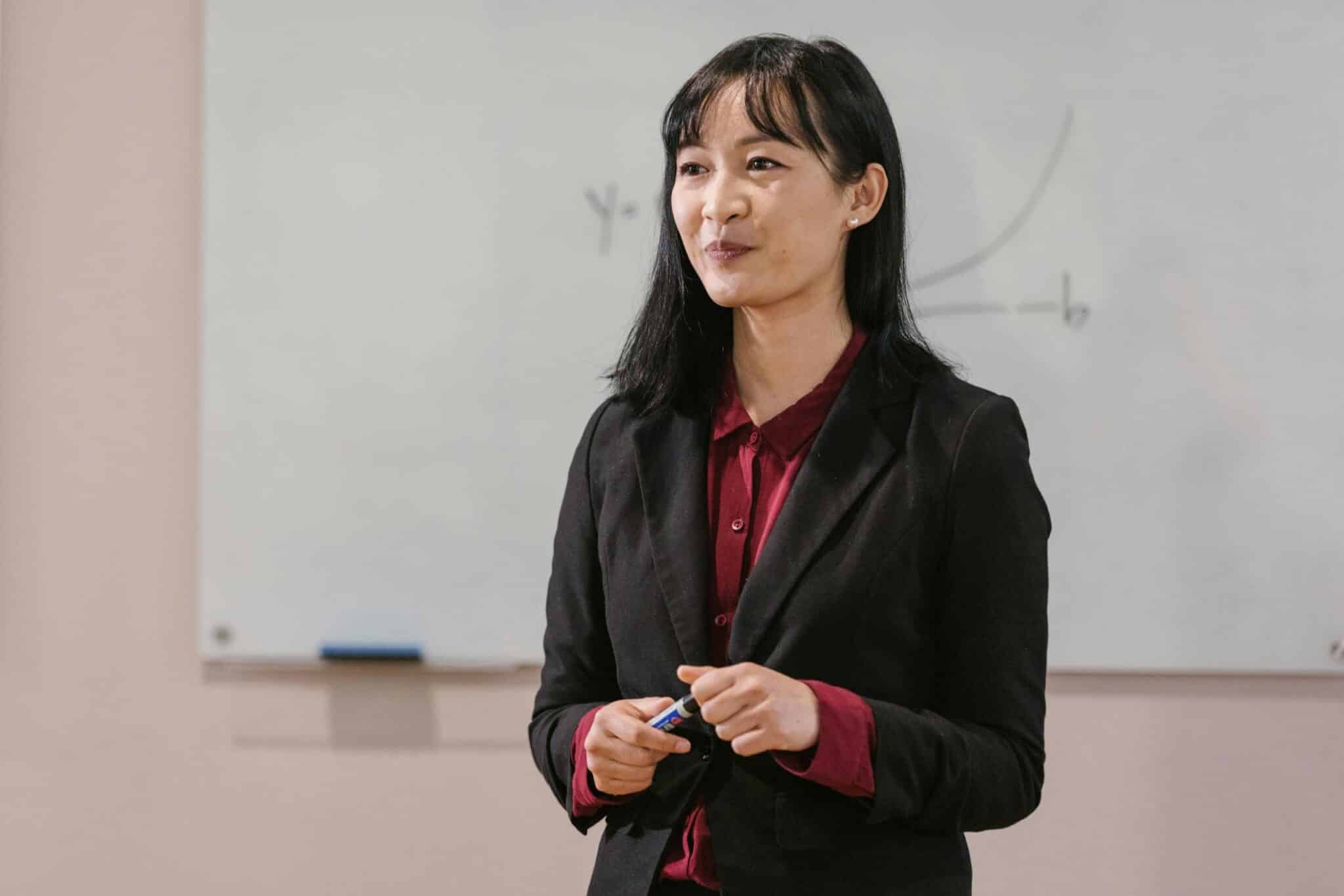 Personal branding photos for media Professional woman presenting in a business meeting with a whiteboard.