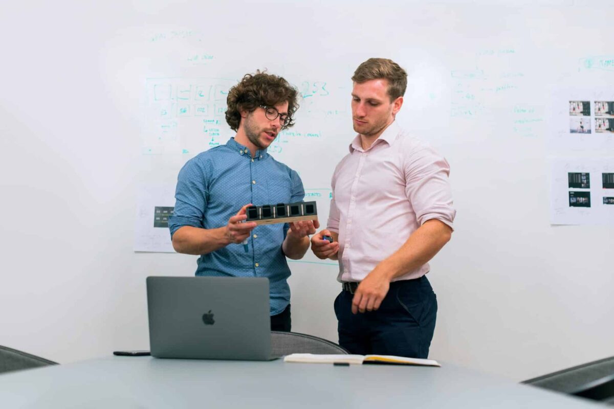 How to Plan Your Branding Session for Launch of a Product or Service 3 Two men in an office discussing and reviewing a tech prototype. Branding Session for Launch