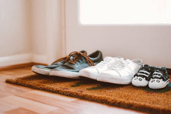 Family Portrait Footwear Cozy family shoes on a doormat at home entrance, symbolizing warmth and connection.