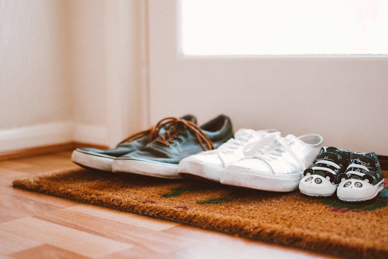 Family Portrait Footwear Cozy family shoes on a doormat at home entrance, symbolizing warmth and connection.